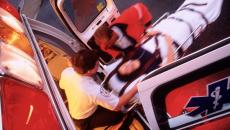 Paramedics rolling a patient onto an ambulance. 