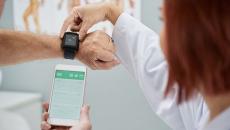 A doctor helping set up a patient's smartwatch.