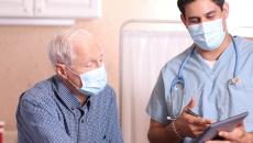 A medical professional with a tablet consults with patient