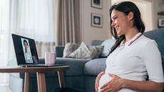 A pregnant person talking to a provider on a tablet