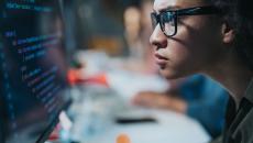 A focused programmer looking at her computer screen