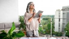 Person on a balcony looking at a tablet