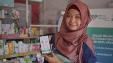 A pharmacist showing the SwipeRx mobile app