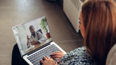 A woman talking to a doctor through a video chat on her laptop