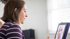 A person talking to a provider on a video call via tablet