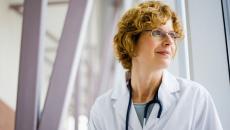 Healthcare provider wearing a stethoscope and looking out a window