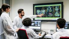 Healthcare providers sitting around a screen analyzing images