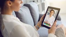 Person speaking to a healthcare provider via a tablet