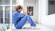 A tired nurse sitting on the floor